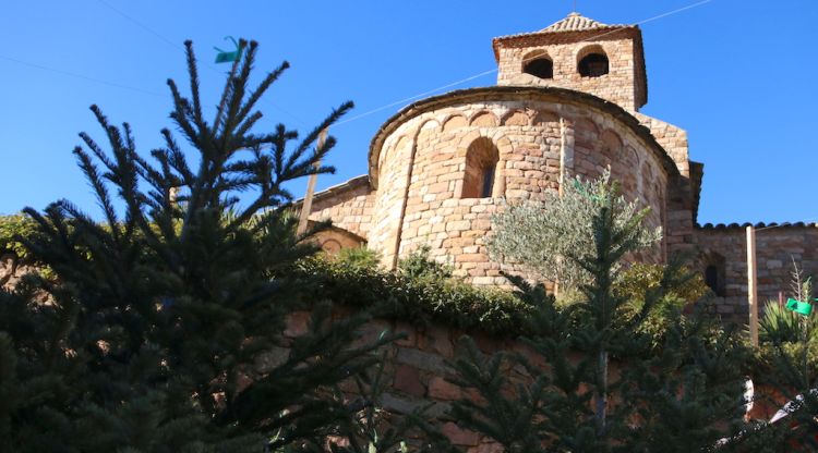 Uns avets en primer terme amb l'església romànica d'Espinelves, de fons (arxiu). ACN