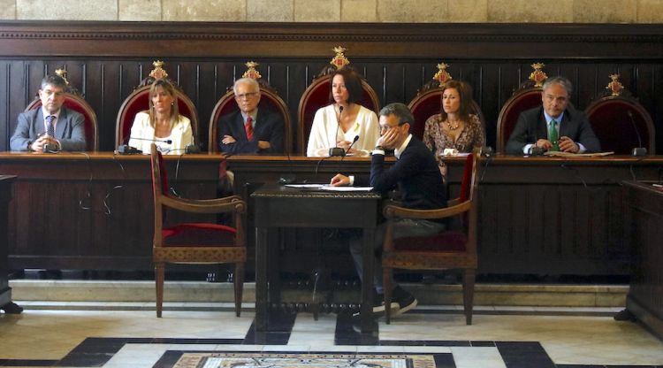 La taula que presideix el ple de Girona, amb la cadira buida d'Isabel Muradàs a la dreta. ACN