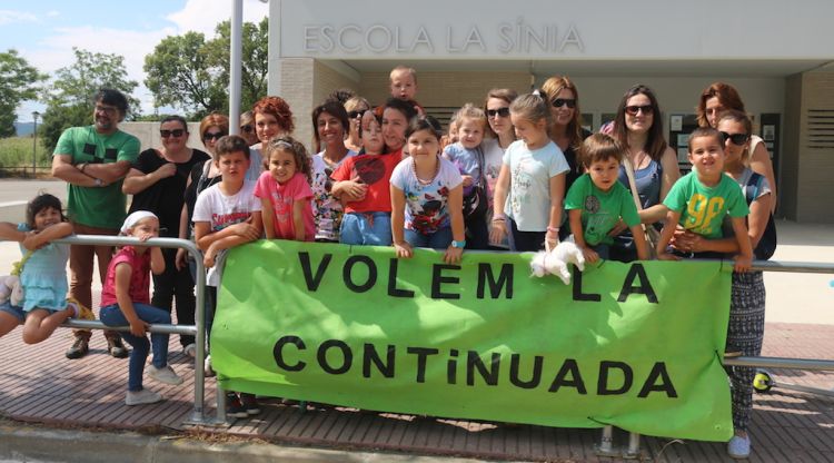 Un grup de pares i alumnes protestant davant l'escola La Sínia de Calonge per reclamar la jornada continuada. ACN