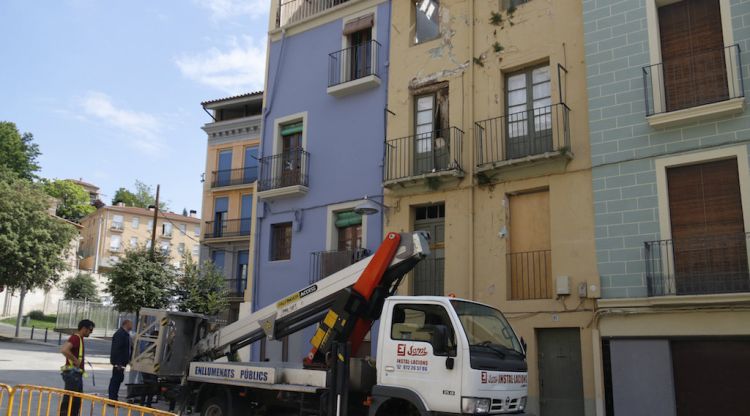 L'edifici esfondrat a la plaça de Campdenmàs, a Olot, i la grua abans de començar la inspecció de l'estat de l'immoble. ACN