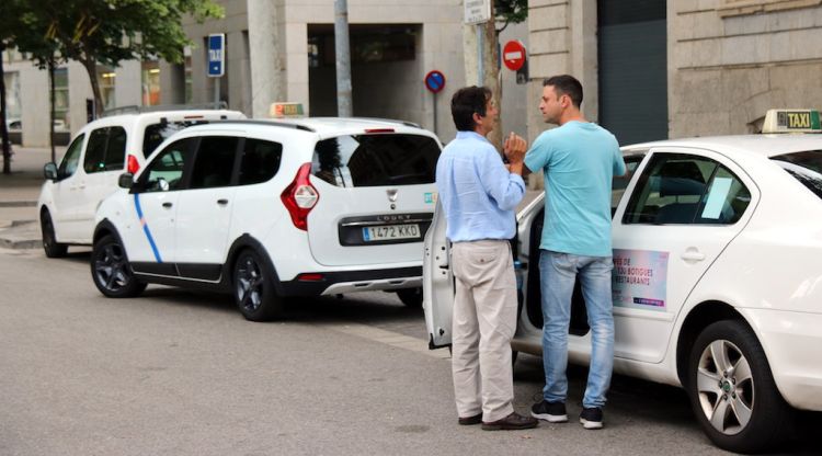 Dos taxistes a la parada de davant de correus de Girona aquest divendres. ACN
