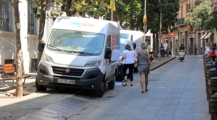 El Carrer Santa Clara de Girona amb tres furgonetes de repartiment a sobre de la vorera per falta d'espai. ACN