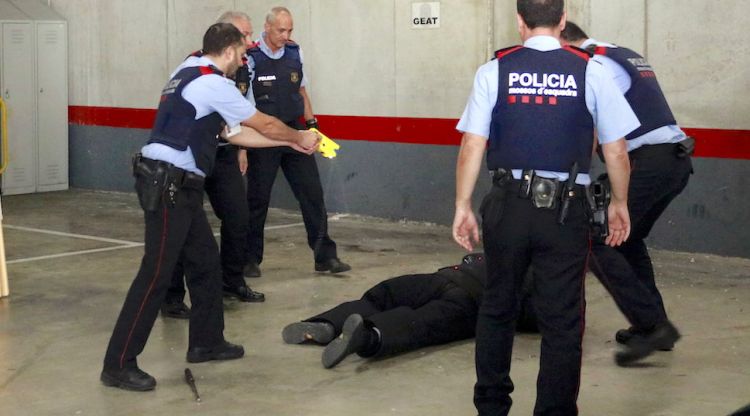 Agents dels Mossos d'Esquadra fent una demostració de com s'utilitza una pistola elèctica (arxiu). ACN