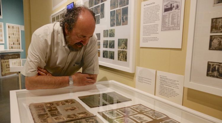 El col·leccionista Albert Rossich contemplant part dels cromos exposats que repassen la història del cinema mut. ACN