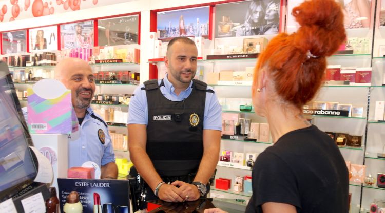 Dos agents de la Policia Local de Platja d'Aro parlen amb una botiguera d'una perfumeria. ACN