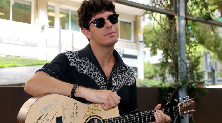 Alfred García, amb la seva guitarra i ulleres de sol, després d'una entrevista a Barcelona. ACN