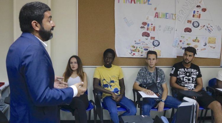 El conseller de Treball, Chakir el Homrani, conversa amb joves del programa 'Nova Oportunitat' a Girona. ACN
