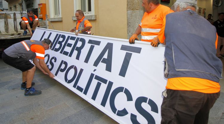Els operaris preparant la nova pancarta per penjar-la a la façana de l'Ajuntament de Blanes