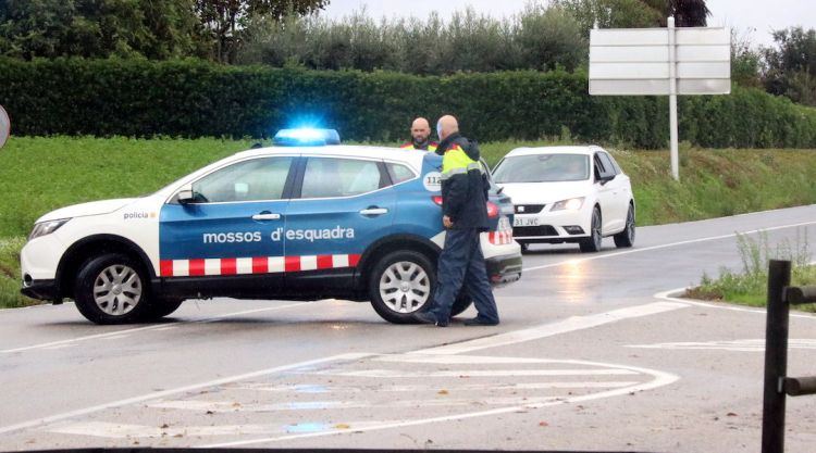 Pla mitjà d'una parella de Mossos d'Esquadra tallant una carretera. ACN