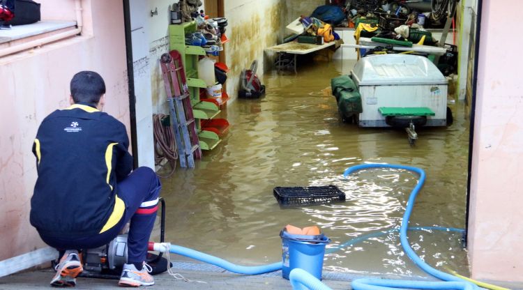 Un veí traient aigua del garatge inundat a Vilatenim, aquest matí. ACN