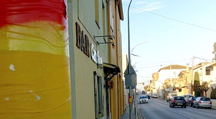 Un dels carrers de Verges amb la bandera espanyola pintada a sobre dels fanals guarnits de groc. Susagna Ribas