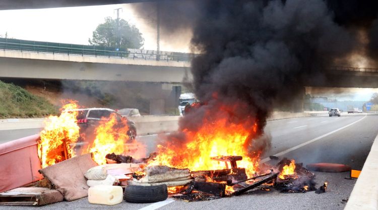 L'incendi amb sofàs cremant i altres mobles a l'autopista AP-7 a Garrigàs. ACN