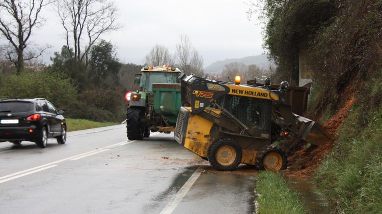 Les màquines treballant per retirar de la calçada la terra caiguda en l'esllavissada, a la C-63 a Anglès © ACN