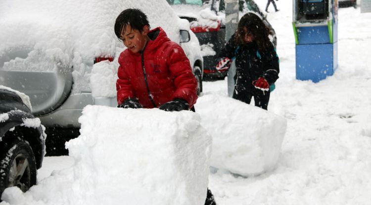 Dos nens jugant a fer voles de neu a un carrer de Sort. ACN