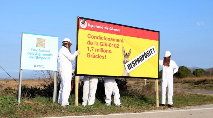 Membres de la IAEDEN amb el cartell de denúncia que han penjat a la carretera. ACN