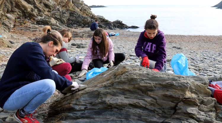 Un grup de persones netejant una de les cales de Cadaqués, aquest matí. ACN