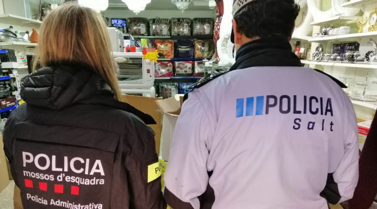 Dos policies d'esquenes inspeccionant un establiment de Salt (Gironès)