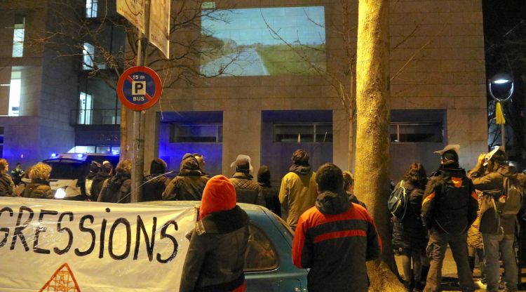 Els concentrats aquest dissabte mirant el vídeo que han projectat a la façana dels jutjats. ACN