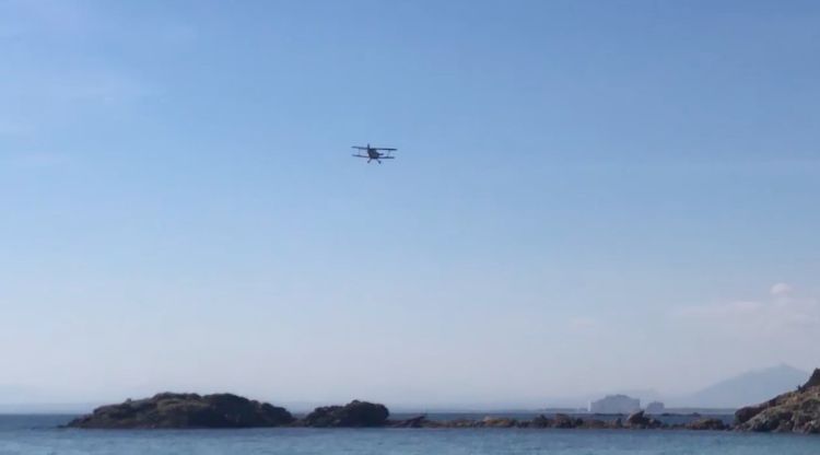 L'avioneta biplà abandonant la cala Almadrava després de les acrobàcies. M. Estarriola