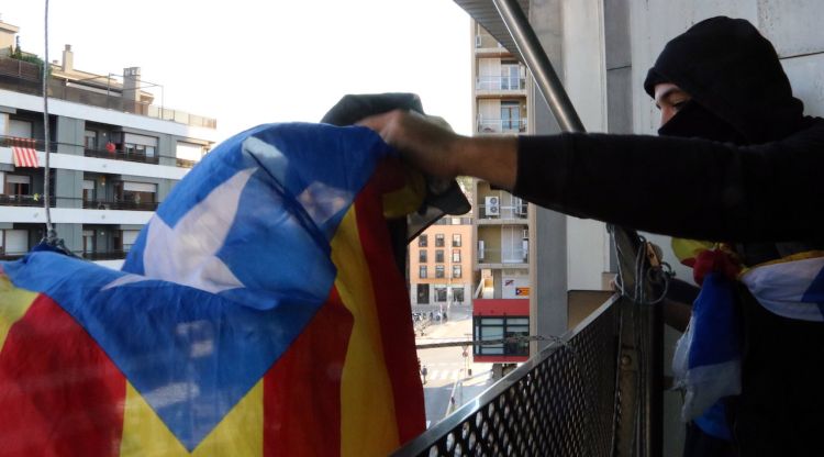 El moment en què un dels manifestants ha penjat una estelada al balcó de la delegació del Govern a Girona. ACN