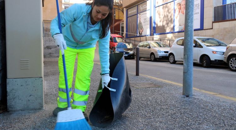 Una treballadora de Girona + Neta, escombrant un dels carrers de la ciutat