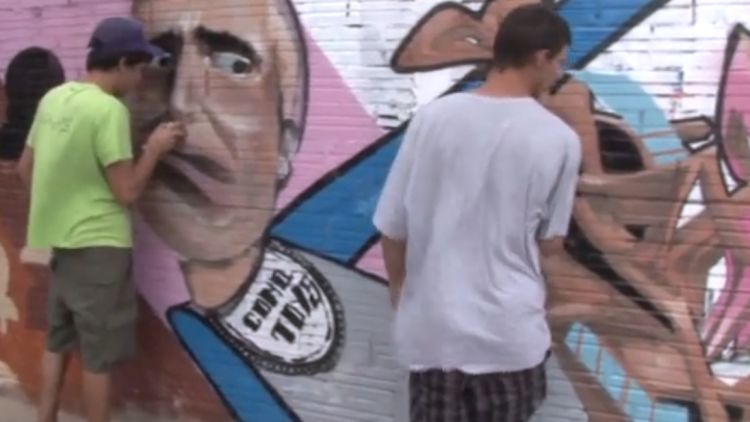 Dos joves fent un grafit en una paret de Figueres © Tramuntana TV