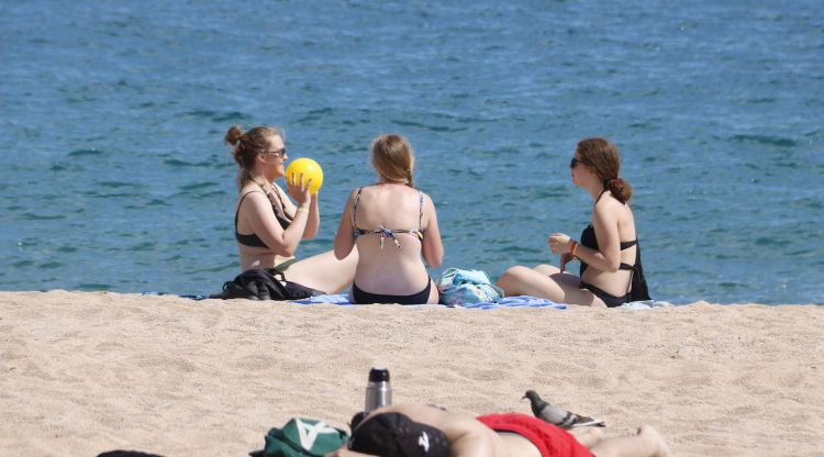 Tres noies jugant amb una pilota a la platja de Lloret de Mar. ACN