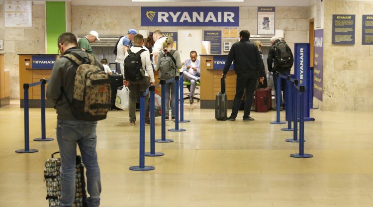 Una petita cua de passatgers esperant el seu torn per facturar l'equipatge en el taulell de Ryanair a l'Aeroport de Girona. ACN