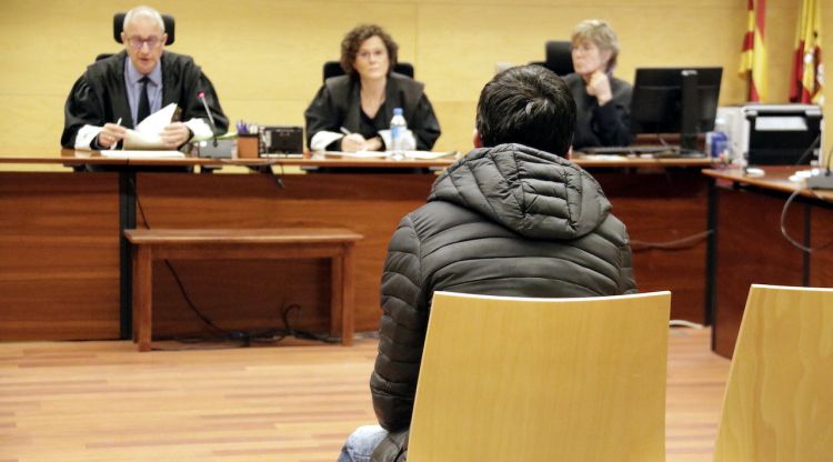 D'esquenes, l'acusat d'intentar clavar un ganivet a un home a Girona. Foto del judici a l'Audiència de Girona. ACN