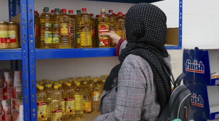 Una usuària del Centre de Distribució d'Aliments de Salt agafant una ampolla d'oli. ACN