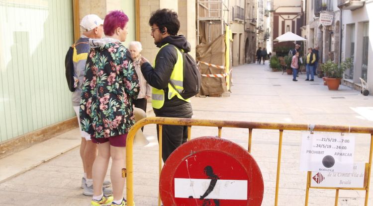 Un vigilant de seguretat explicant a uns turistes que no poden accedir al casc antic. ACN