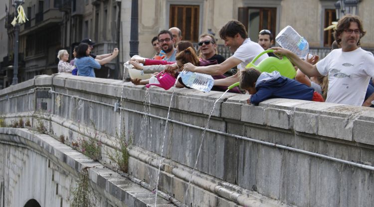 Els participants a la palanganada del Ter tirant aigua al riu Onyar. ACN