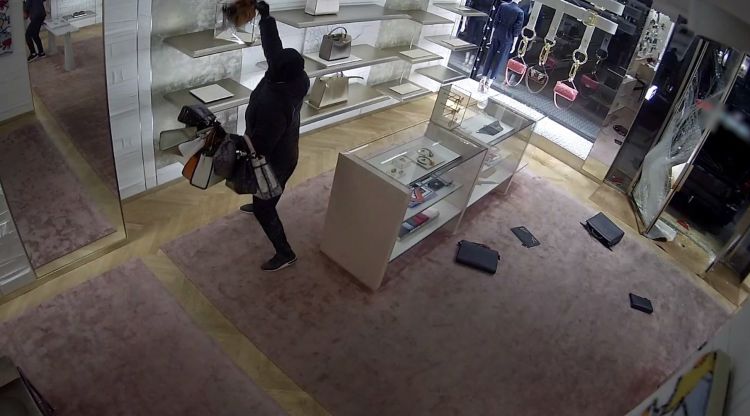 Captura de video d'una càmera de seguretat en el moment que un grup criminal roba bosses de mà en una botiga