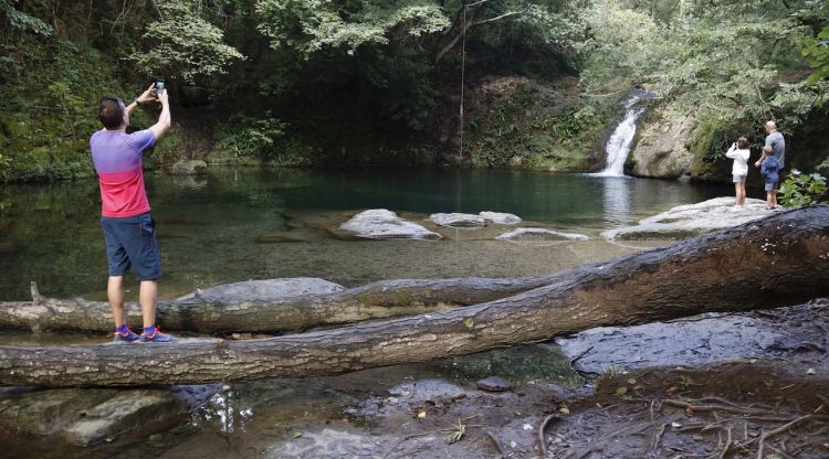 Un dels salts de les Planes d'Hostoles (Garrotxa) amb visitants fent fotos respectant l'entorn. ACN