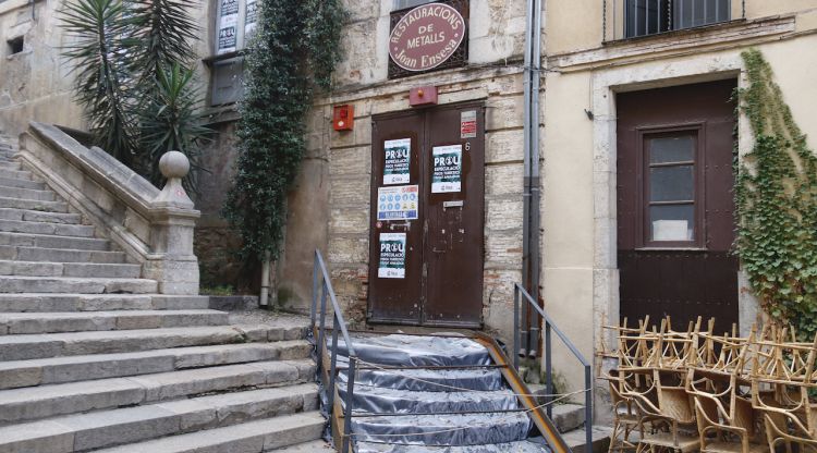 Porta de l'antic teatre Odeón amb alguns cartells de la Forja en contra de l'augment de turisme a Girona. ACN