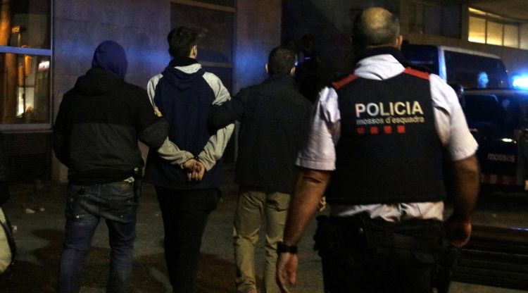Els Mossos portant emmanillat un dels detinguts a Girona durant la quarta nit de disturbis. ACN