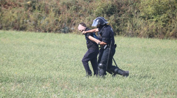 Dos agents de la Brigada Mòbil retenint un home que presumptament intentava tallar l'AP7 a Llers. ACN