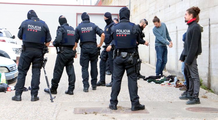 Agents dels Mossos escorcollant algunes persones a l'aparcament proper a l'Ap-7 a la Jonquera. ACN