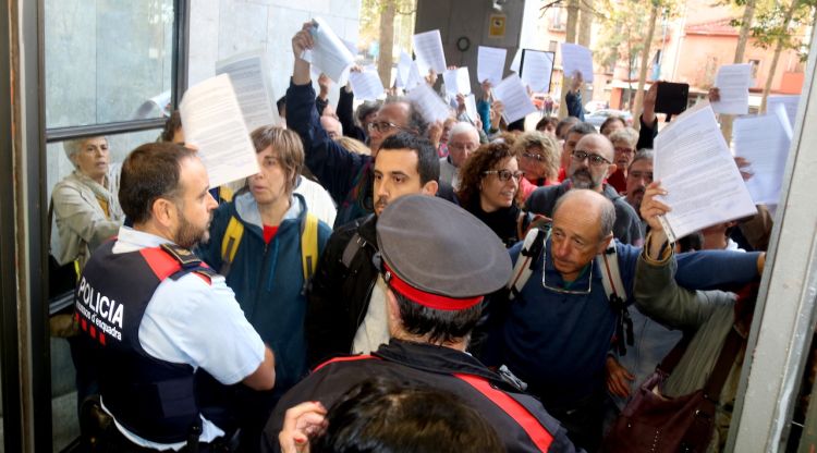 Els Mossos barrant el pas als qui volien autoinculpar-se a Girona avui i la gent ensenyant els papers i cridant "Volem entrar! Volem entrar!". ACN
