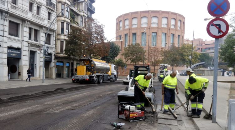 El operaris reparant aquest matí el tram de l'avinguda Jaume I malmès pel vessament de cera i la crema de contenidors durant els disturbis. ACN