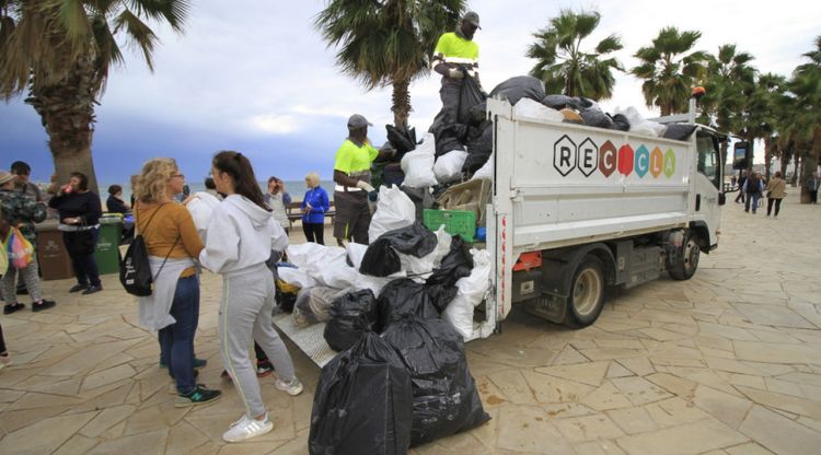 Diversos participants de la marxa Mou-te pel Mar a Blanes dipositant les bosses plenes de deixalles