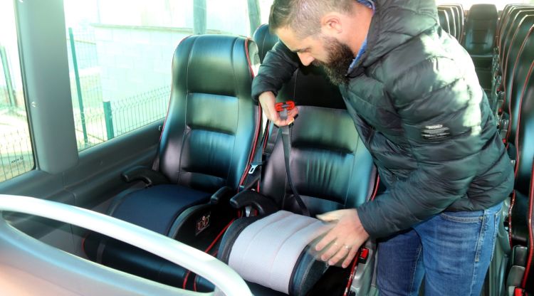 El president de l'AMPA de Vilobí d'Onyar col·locant un elevador a l'autobús escolar. ACN