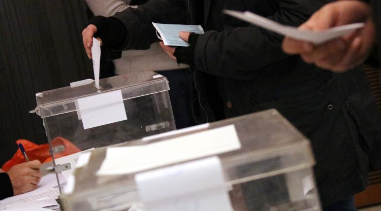 Una mà diposita un vot en una urna, amb una segona urna en primer pla. ACN