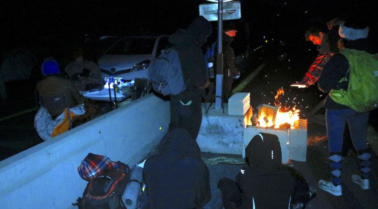 Manifestants amb una foguera i altres sopant al costat a l'AP-7 a la Jonquera. ACN