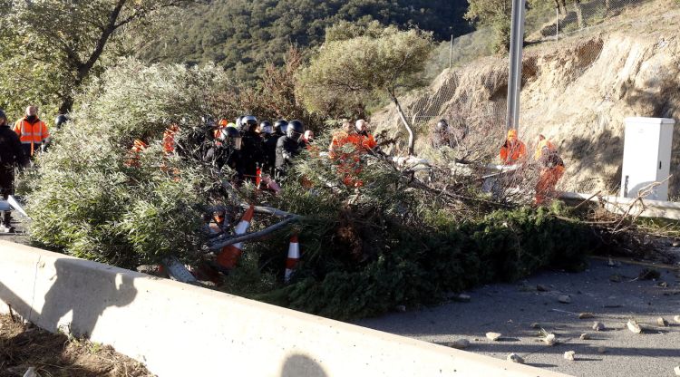 Mossos i operaris retirant les tanques que servien com a barricades a la Jonquera. ACN