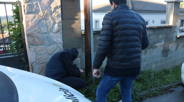 Dos operaris treballant en una casa amb la llum punxada. ACN