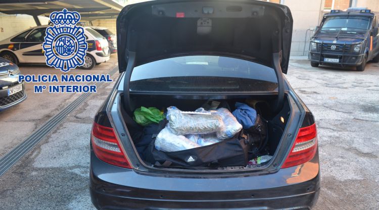 Pla obert del maleter d'un cotxe amb diverses bosses de marihuana dins d'una motxilla