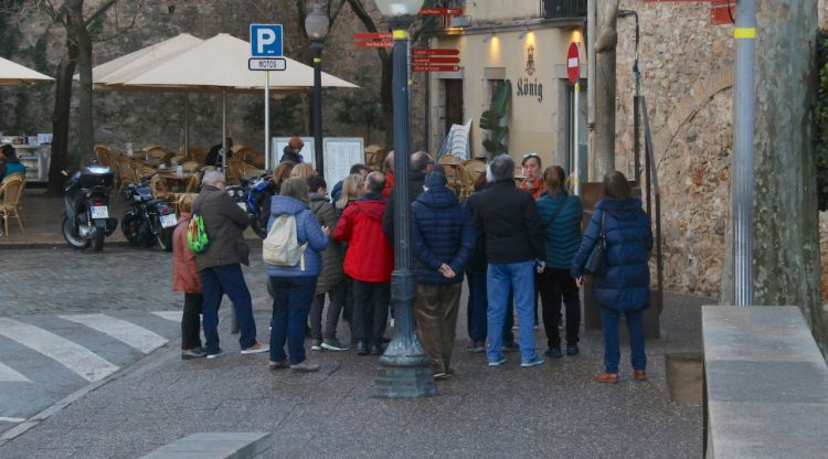 Un grup de turistes escoltant un guia, ahir al Cul de la lleona de Girona. ACN