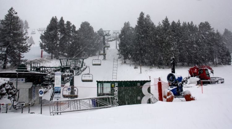 Un telecadira de l'estació de La Molina (Cerdanya) totalment aturat, un canó de neu i una màquina trepitjaneu aturades. ACN