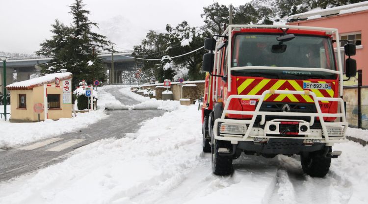 Un camió de bombers francès aparcat en una cantonada i de fons el Pertús totalment nevat. ACN
